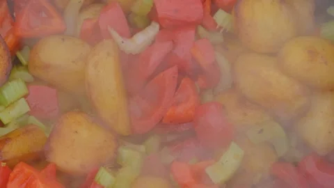 Frying vegetables in a cauldron. Vegetables are fried in a cauldron over a fire Stock Footage 280354958