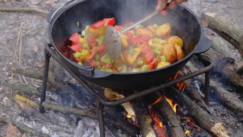 Frying vegetables in a cauldron. Vegetables are fried in a cauldron over a fire Stock Footage 280929014