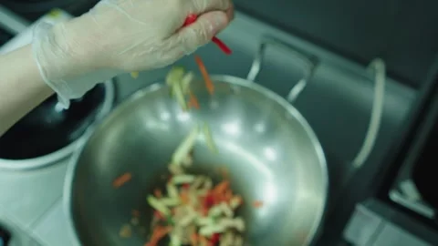 Frying vegetables in a hot iron deep frying pan. Wok frying. Stock Footage 331865560