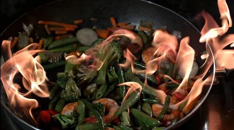 Frying vegetables in a pan in the air Stock Photos