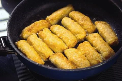 Frying Vietnamese spring rolls in black pan Stock Photos