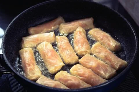Frying Vietnamese spring rolls in black pan Stock Photos