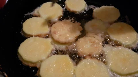 Frying zucchini and turning it with metal fork. Vegan food concept Stock Footage 92525981