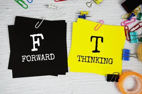 FT - Forward Thinking text on stick note with stationery on concrete backgrou Stock Photos