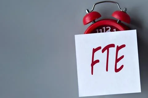 FTE (Full Time Equivalent) - acronym on a white piece of paper on a gray back Stock Photos