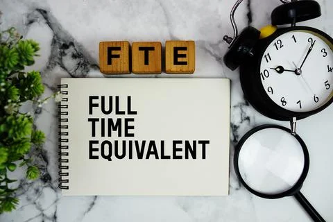 FTE Full Time Equivalent text with alarm clock and magnifying glass on marb.. Stock Photos