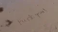 Fuck you written in sand washed away by wave HD Footage