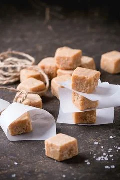 Fudge candy and caramel on baking paper, served over dark background. Stock Photos