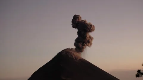 Fuego Volcano eruption with dense ash plume rising above summit at sunset Stock Footage 334450053