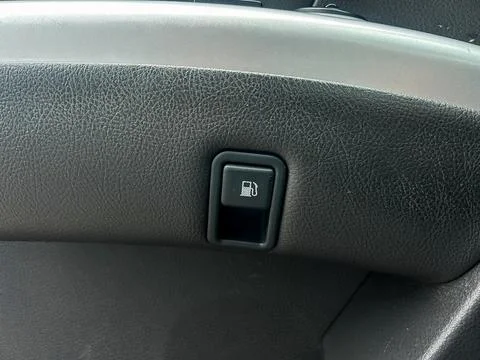 Fuel door release button is located inside a car dashboard near the steerin.. Stock Photos
