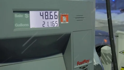 Fuel gallon and dollars going up in winter snow storm Stock Footage 71693796