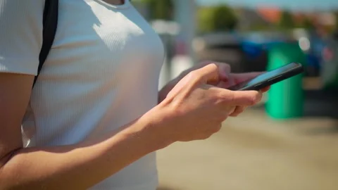 Fuel payment using smartphone near gas station pumps during sunny day. Female Stock Footage 336969598