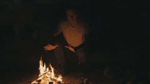 Fugitive man warms up by fire and runs away frightened Video stock 91031545
