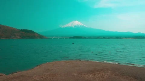 Fuji mountain view with A group of small boats are sitting on a rocky shore Stock Footage 313416707