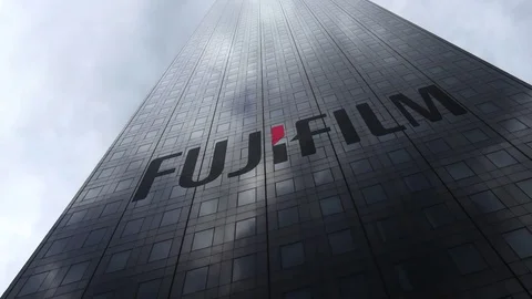 Fujifilm logo on a skyscraper facade reflecting clouds, time lapse. Editorial 3D Video stock 81112314