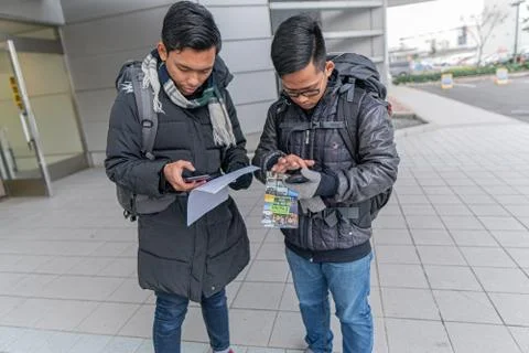 Fukuoka, Japan - January 17 2020: Tourists are reading their travel itinerary Stock Photos