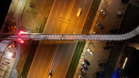 Full aerial time lapse view of night flowing traffic and people using overpass Stock Footage 244801465