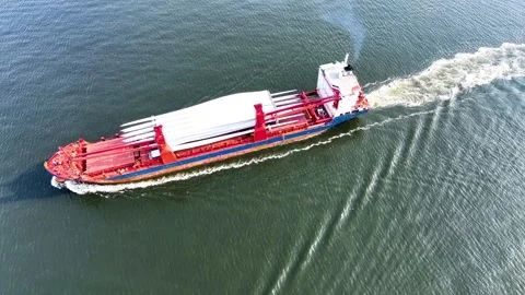 Full aerial view of red cargo ship carrying weather vane propeller, advancing Stock Footage 242760962