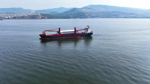 Full aerial view of red cargo ship carrying weather vane propeller, advancing Stockbeeldmateriaal 242760989