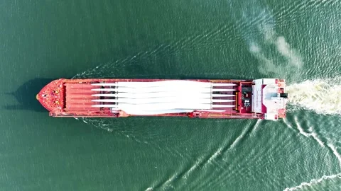 Full aerial view of red cargo ship carrying weather vane propeller, advancing Stock Footage 242761021