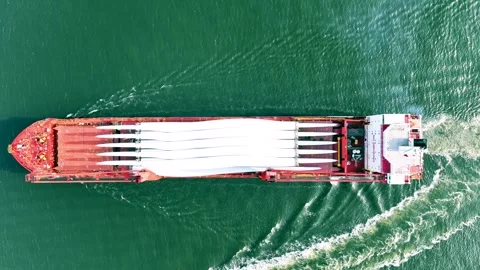 Full aerial view of red cargo ship carrying weather vane propeller, advancing Stock Footage 242761088