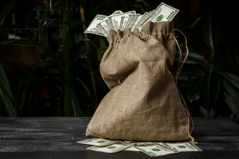 A full bag of dollars on a dark table Stock Photos