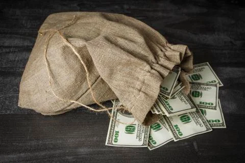 A full bag of dollars on a dark table Foto stock