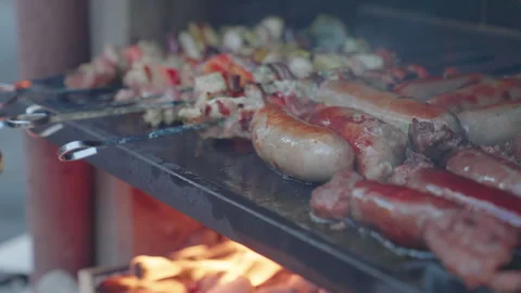 Full BBQ grill of kebabs and sausages. Outdoor BBQ during fun summer party Stock Footage 345806230