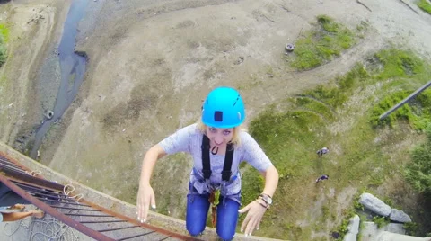 Full blonde jumping from the bridge back covering her face with her hands Stock Footage 53349584