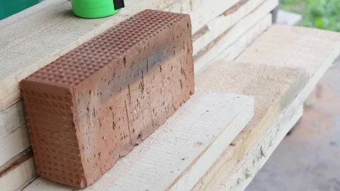 Full-bodied red building bricks in the hands of the worker Video stock 77198121