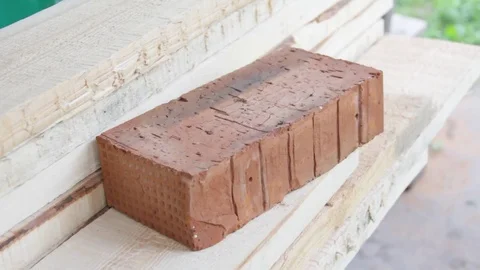 Full-bodied red building bricks in the hands of the worker Video stock 77198140