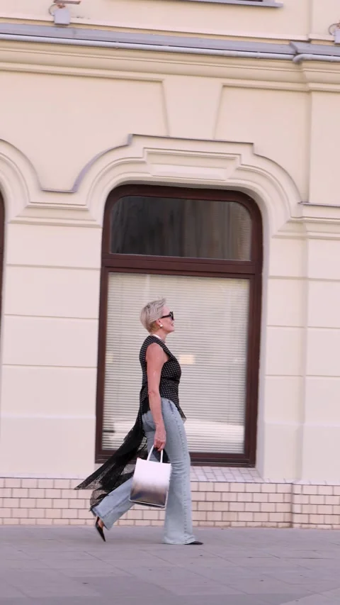 Full body side view of elegant Mature woman with short hair walking outdoors Stock Footage 318459205