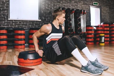 Full body view of young trainer man doing triceps exercices on stepper in aer Stock Photos