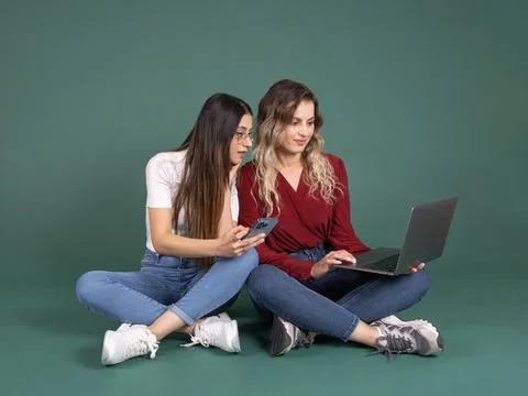 Full body view young two caucasian women sit floor together hold use laptop Stock Photos
