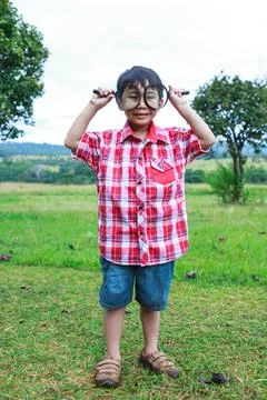 Full body. Young boy exploring nature with magnifying glass. Outdoors. 스톡 사진