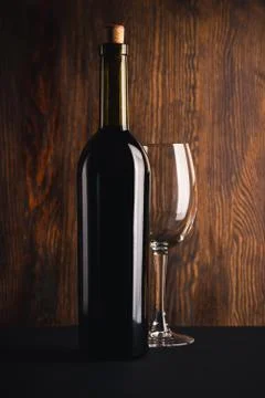 Full bottle of wine and empty glass Stock Photos