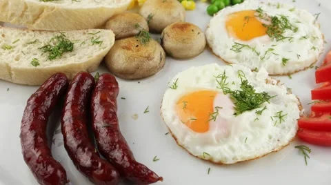 Full breakfast with scrambled eggs, sausages and vegetables (loop) Video stock 57998037