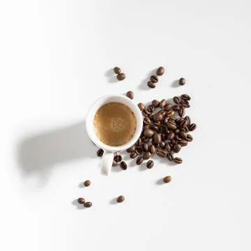 Full coffee cup on white background with beans Stock Photos