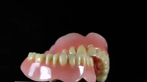 Full dentures lower and upper jaw that spin in circles Stock Footage 80797307