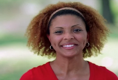 Full-face portrait of a smiling young woman with an aureole of curls Stock Footage 86914682