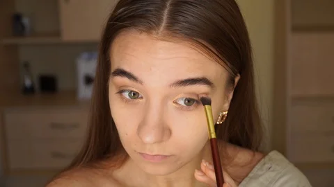 Full face woman is making up using a brush colouring her eyes Stock Footage 128521631