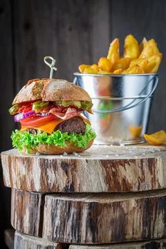 Full filled hamburger served with chips. American cuisine. Stock Photos