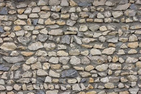 Full frame background and texture of ugly sharp stone wall with concrete between Foto stock