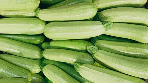Full frame background of fresh ripe green zucchini on display at a supermar.. Foto stock