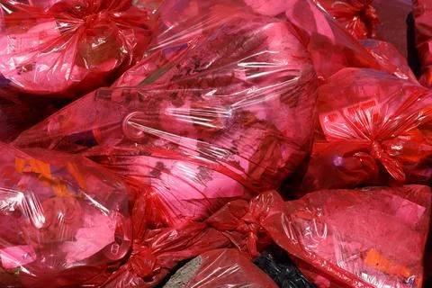 Full frame background of rec plastic trash bags with generic domestic waste 스톡 사진