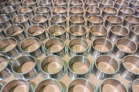 Full frame batch array of shiny steel cylindrical sleeve parts with flange Stock Photos