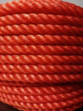 Full frame of bundle of orange rubber fiber rope coil. Stock Photos