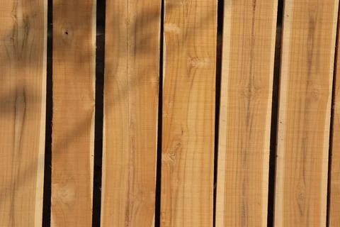 Full frame captures lumber of rectangular wooden planks aligned to form a fen Foto stock