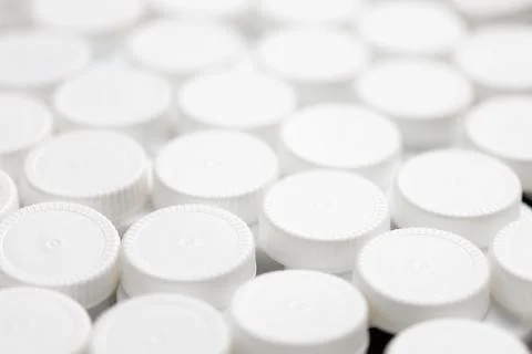 Full frame close-up background filled with white hdpe plastic bottle caps Stock Photos