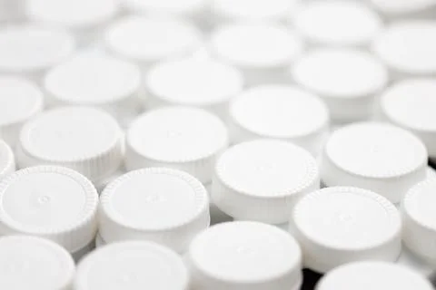 Full frame close-up background filled with white hdpe plastic bottle caps Stock Photos